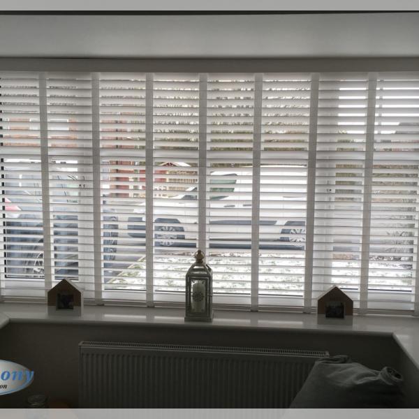 White FauxWood Blinds with Ladder Tapes in a Bay Window